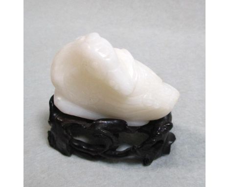 A white jade duck , 19th century or later, the resting duck sitting with head turned back, on a wooden stand, 5cm long  