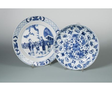 Two Kangxi dishes, one painted with two ladies and three children playing by a fence outside a pavillion, 25.5cm diameter; th