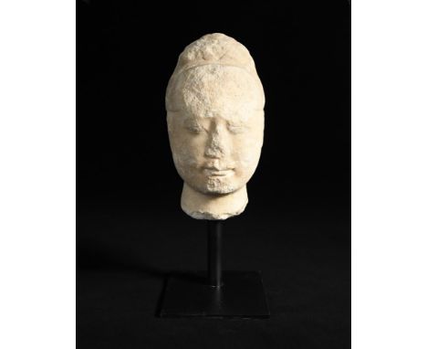 A rare white marble head of a buddhist donor, Tang dynasty, wearing a hoe and with calm and serene smiling expression, whilst