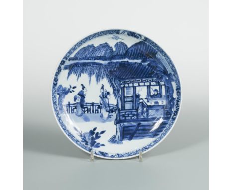 A Kangxi dish, painted with two ladies below a willow tree whilst a man is playing with a stringed instrument within a pavill