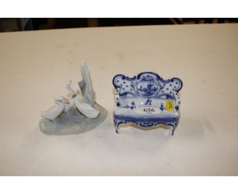 A blue and white porcelain Delft patterned miniature sofa; and a Nao porcelain figure group of ducks 