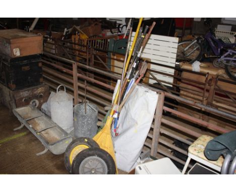 A quantity of garden hand tools; two wheelbarrow wheels; a garden sprinkler etc.
