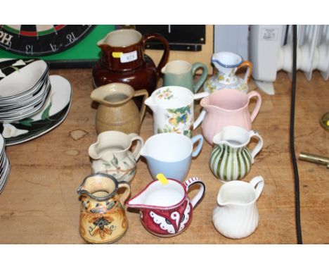 A collection of various pottery and porcelain jugs 