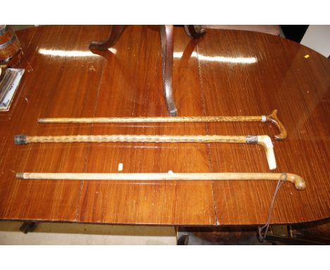 A horn handled walking stick with white metal band; and two other vintage walking sticks 