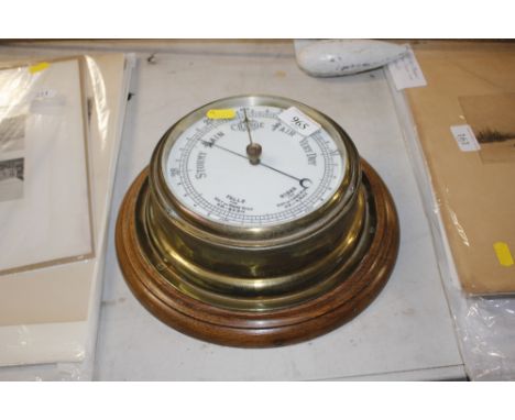 A brass and oak mounted bulkhead type barometer 