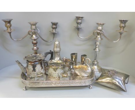 A pair of silver plate on copper candelabra, lacking one sconce, a silver plate on copper tray, a three piece plated bachelor