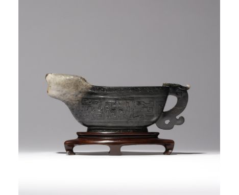 A CHINESE ARCHAISTIC BLACK AND WHITE JADE POURING VESSEL, YI 18TH CENTURY Decorated in low relief to the exterior with taotie