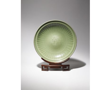 A LARGE CHINESE LONGQUAN CELADON DISH MING DYNASTY The heavily potted body rising from a short tapering foot to a lipped rim,