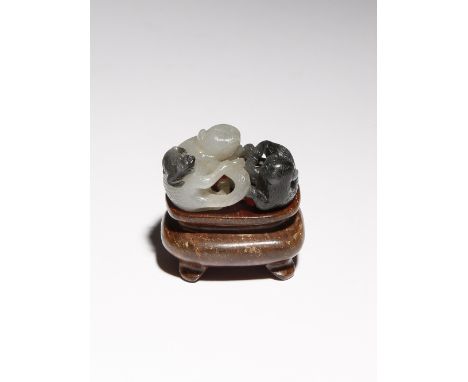 A SMALL CHINESE WHITE AND BLACK JADE CARVING OF CATS QING DYNASTY OR LATER Formed as two reclining cats facing each other, wi