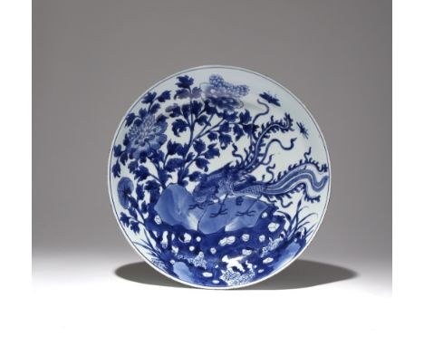 A LARGE CHINESE BLUE AND WHITE 'PHOENIX AND PEONY' DISH KANGXI 1662-1722 The deep sides rising from a tapering foot to a slig