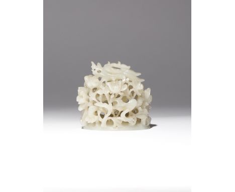 A CHINESE WHITE JADE 'DRAGON' HAT FINIAL MING DYNASTY Carved in openwork with a sinuous dragon coiling itself amongst many fl