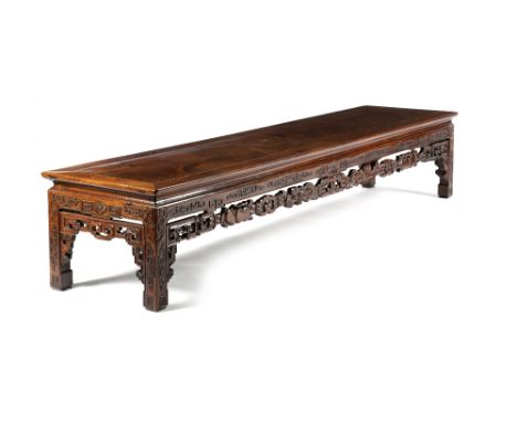 A CHINESE PADOUK LOW TABLE LATE 19TH CENTURY The panelled top above a scroll-decorated frieze and a pierced apron carved with