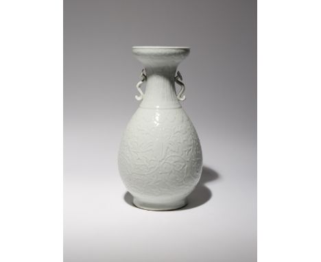 A CHINESE WHITE GLAZED PEAR-SHAPED VASE 18TH CENTURY Carved with flowers growing amongst scrolling leafy branches, the design