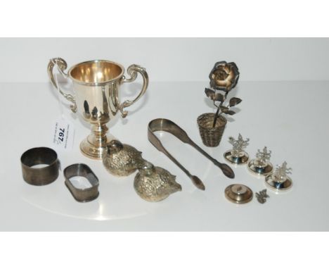 A lot comprising a silver trophy cup, rubbed marks 12 cm high, silver sugar tongs, two silver napkin rings, a pair of white m