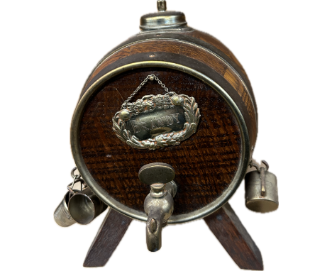 A vintage retro brandy dispenser / decanter in the form of a wooden barrel raised on four splayed legs, with label and tap to