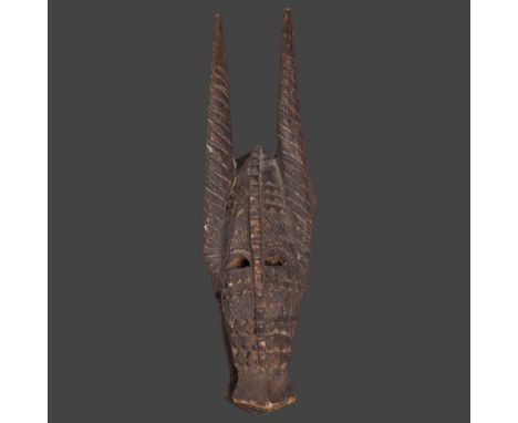An African tribal carved wood Senufo Bobo zoomorphic helmet mask in the form of a horned creature, height 61cm. 