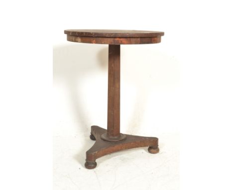 A Regency 19th century rosewood wine table being raised on a tripod base with bun feet having hexagonal column with circular 