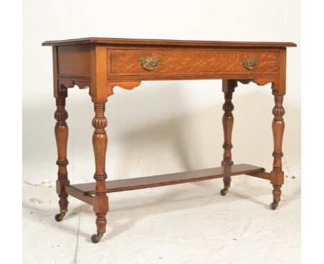 A good Victorian 19th century oak and leather writing table desk. Raised on turned legs with castors having lower tier unitin