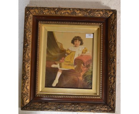 An early 20th Century Edwardian gouache on paper portrait of a young girl seated wearing a yellow dress clutching flowers hav