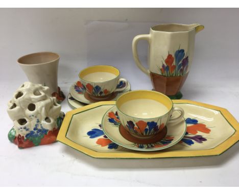 A collection of Clarice Cliff comprising jug two cups and saucers sandwich plate decorated in the crocus pattern, and a vase