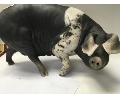 A 20 th century pottery model of a pig 24 cm by 33 cm .
