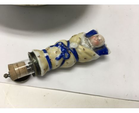A collection of ceramics including a Victorian perfume bottle in the form a cradled baby and a set of iron stone plates .