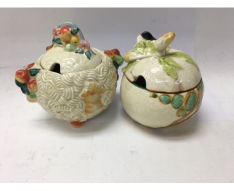 Two Clarice Cliff preserve jars and covers .