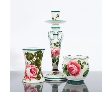 THREE WEMYSS ROSE PAINTED ITEMS comprising a candlestick and two small vases, and all painted with roses with a green border 