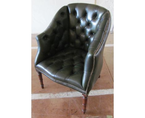 A leather button upholstered tub shaped chair on ring turned supports
