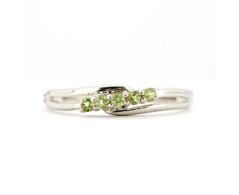 A 9ct white gold ring set with peridots, (N).