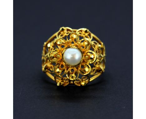 A 22ct yellow gold flower ring set with cultured pearl, (N). Weight - 6g