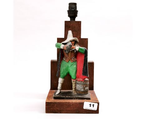 A 19th century painted cast iron figure of Guy Fawkes mounted on an oak table lamp, overall H. 32cm.