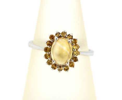 A 9ct white gold cluster ring set with a cabochon cut citrine surrounded by round cut citrines, (M.5).