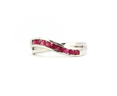 A 9ct white gold ring set with rubies, (N).
