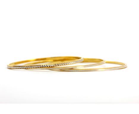 A pair of 22ct yellow and white gold bangles (marked 22K) with a further 22ct yellow and white gold bangle. Weight - 33g