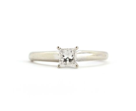 A 14ct white gold (stamped 14k) solitaire ring set with a princess cut diamond, (J).