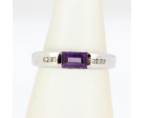A 9ct white gold ring set with a baguette cut amethyst and diamond set shoulders, (M.5).