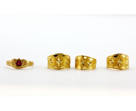 Four small yellow metal (tested high carat gold, approx. 22ct) rings, one set with a round cut ruby. Three adjustable. Weight