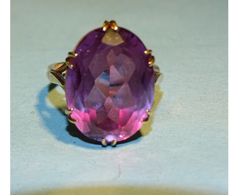 A 9ct gold dress ring claw set a large amethyst coloured synthetic sapphire, R, 8.5g. 