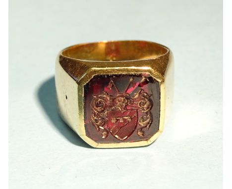 An unmarked gold signet ring set square intaglio carved with a coat of arms, (cracked), tested as 14-18ct gold, size J, gross