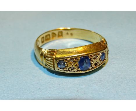 An 18ct gold gypsy ring set three sapphires and diamond points, (two diamonds missing), size K, 3.4g. 