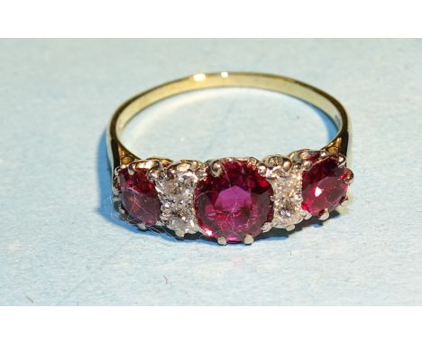 A ruby and diamond ring, claw set three oval rubies with pairs of old brilliant cut diamonds between in 18ct yellow gold moun