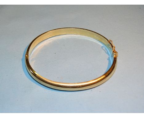 A 14ct yellow gold plain hinged bangle, interior dimensions 6.5 x 6cm approximately, 13g. 