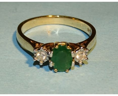 A 9ct gold ring set an oval emerald between two illusion-set diamonds, size M, 3g. 