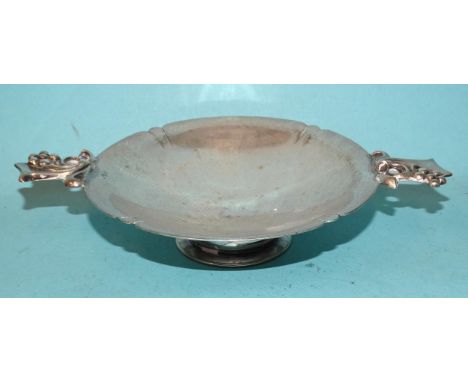 A small silver two-handled circular bonbon dish on circular foot, the handles decorated with ribbon and berries, 17cm wide, 3