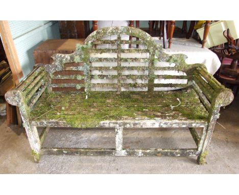 A teak garden bench adorned with mosses and lichen, 164cm wide. 