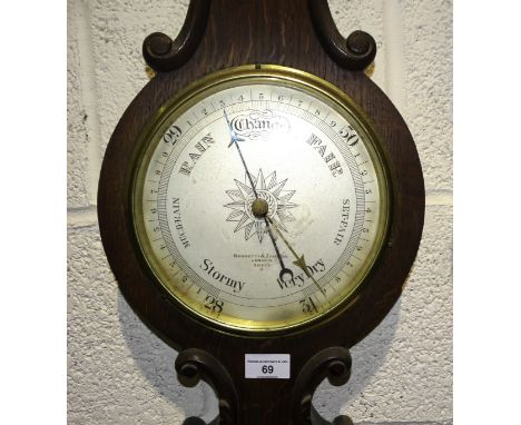 A Negretti and Zambra aneroid wheel barometer and thermometer in oak case, 93cm high. 