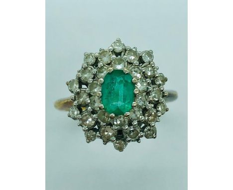 A Diamond and Emerald ring set in a hallmarked 18ct gold setting