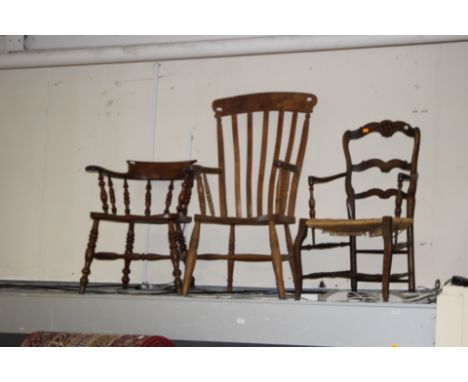 A collection of various chairs, comprising an elm captains chair, an elm seated open armchair and a rush seated ladder back c