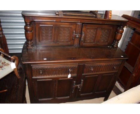 An Ercol oak dresser, doors to upper section, the base with two drawers over two doors 